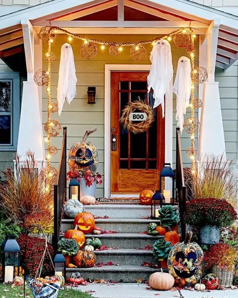 porche décoré pour Halloween avec fantômes suspendus, guirlande lumineuse et couronne BOO