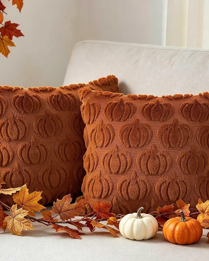 Housses de coussin en fausse fourrure rouille à motifs de citrouilles en relief sur un canapé
