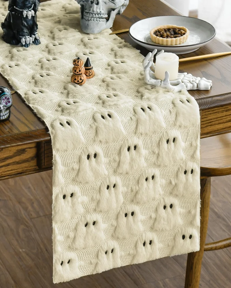 Chemin de table crème à motifs de fantômes en relief sur une table en bois