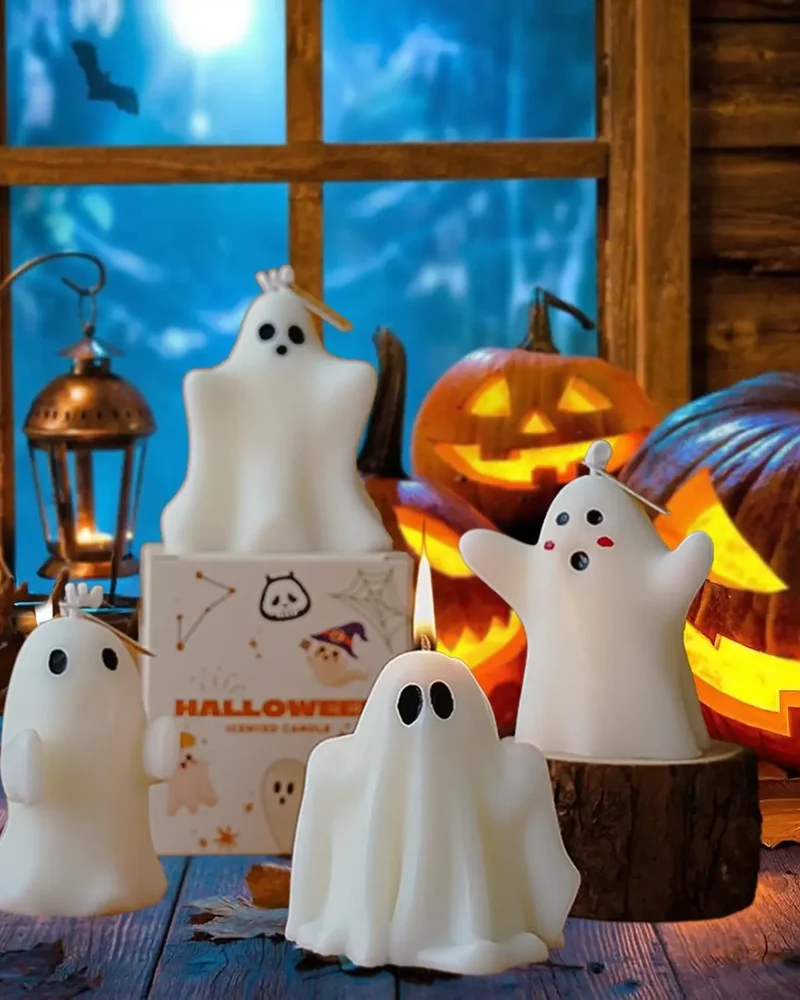 Bougies en forme de petits fantômes blancs devant des citrouilles sculptées illuminées