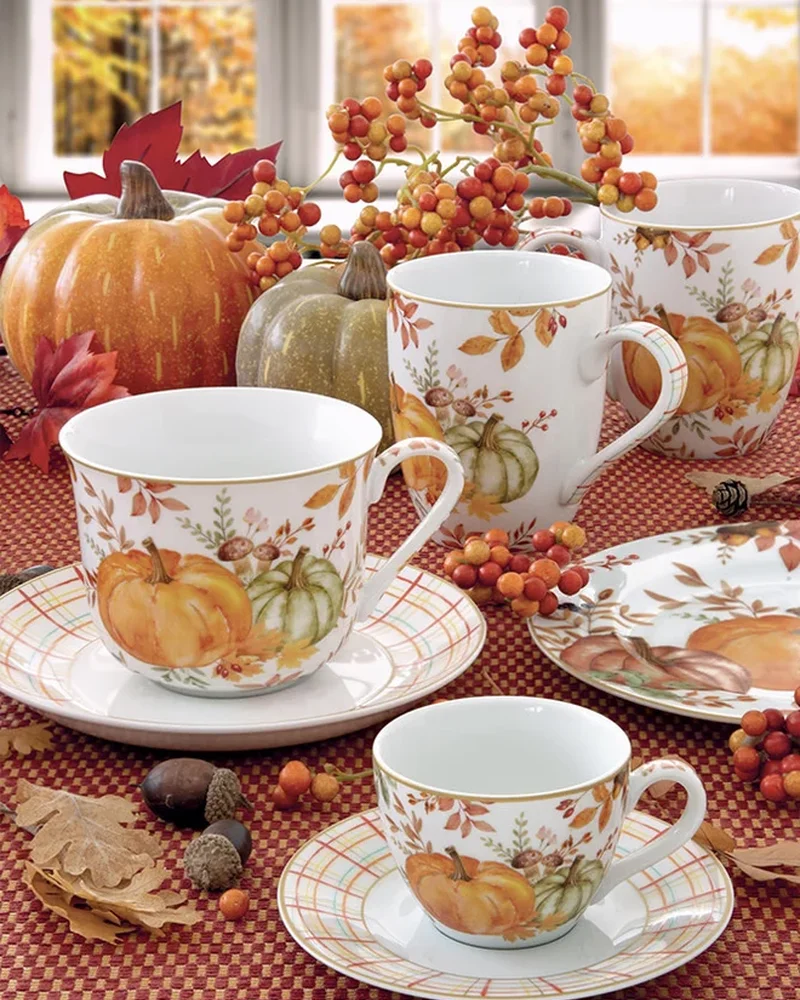 Tasses et assiettes en porcelaine illustrées de citrouilles et feuillages d'automne
