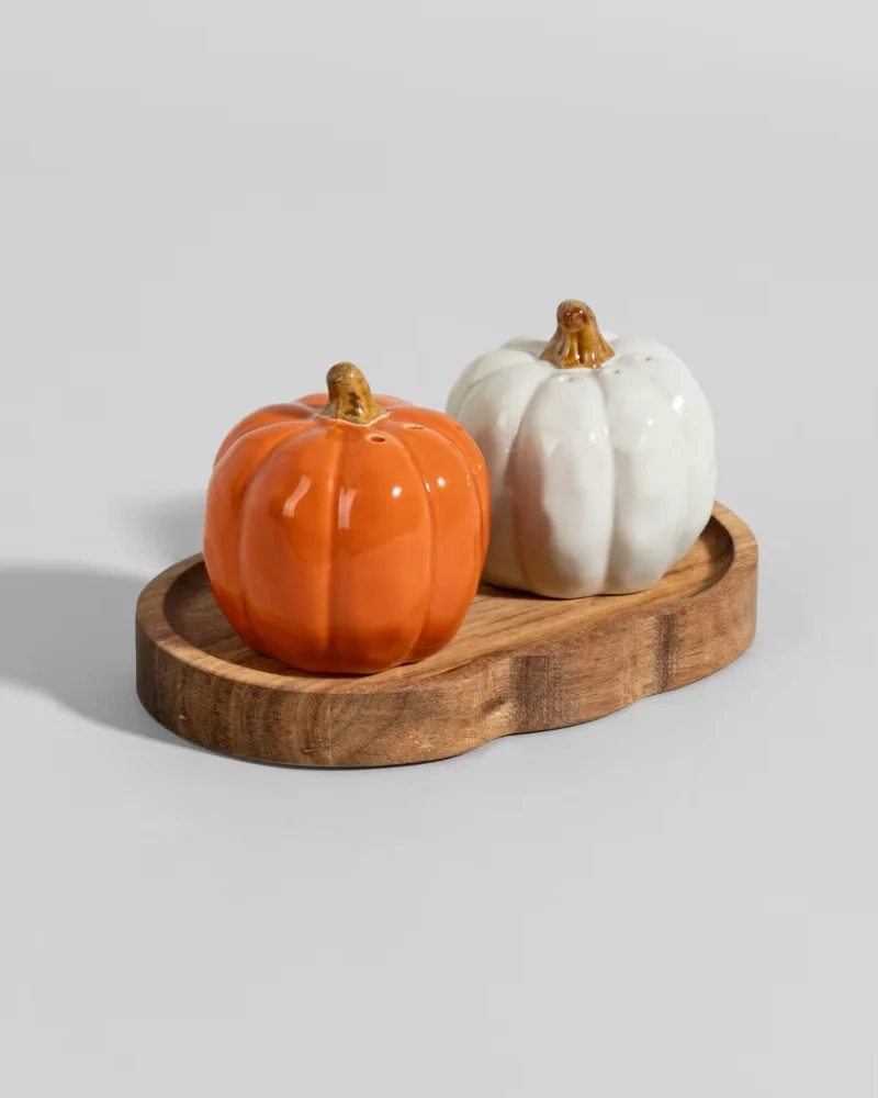 Salière et poivrière en céramique en forme de citrouilles orange et blanche sur socle bois