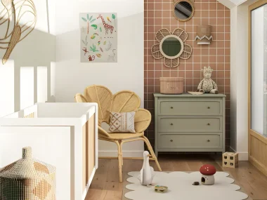 Chambre de bébé lumineuse avec commode vert sauge, lit blanc, fauteuil en rotin et tapis festonné