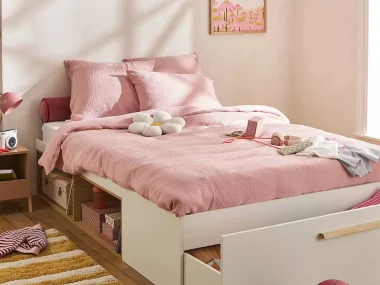 Chambre d'enfant rose avec lit blanc à rangements, tiroir sous le sommier et linge de lit rose