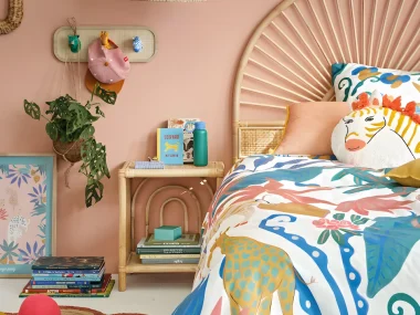 Chambre d'enfant colorée avec table de chevet en rotin, tête de lit en rotin et linge de lit illustré