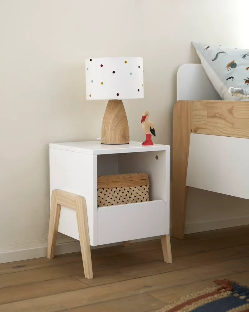 Table de chevet enfant blanche avec niche ouverte et panier, posée sur des pieds en bois clair