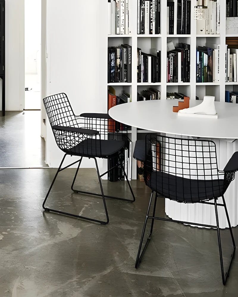 Chaises filaires noires à accoudoirs Wire de HKliving autour d'une table ronde blanche