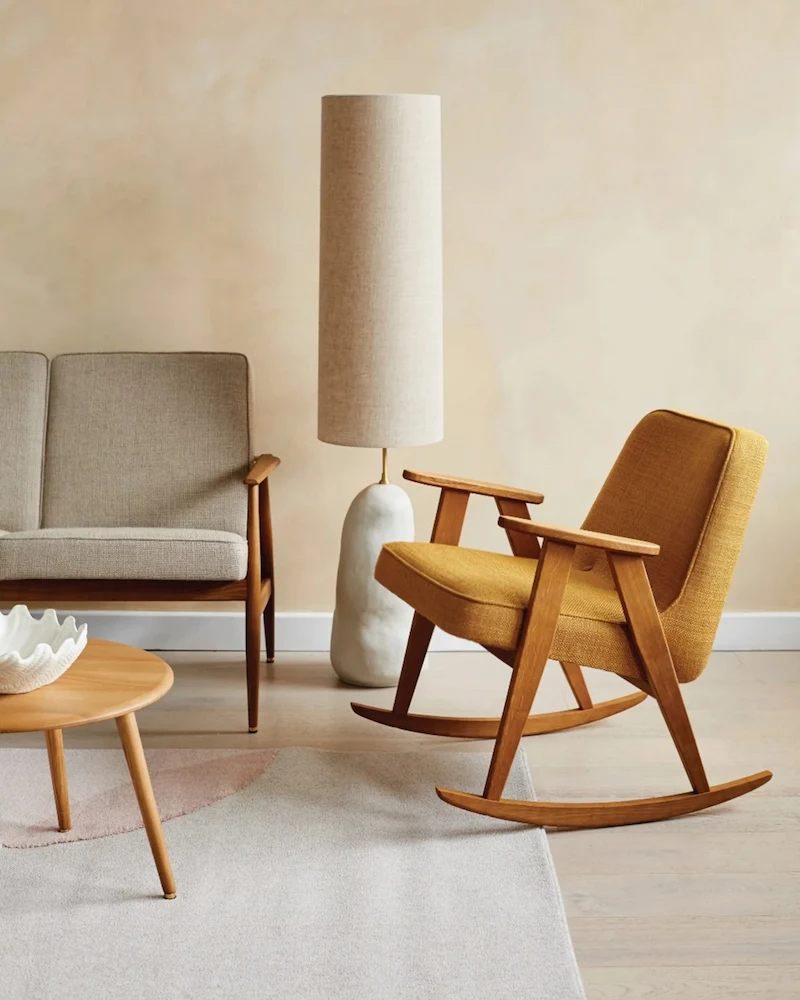 Chaise à bascule 366 en velours ocre moutarde et structure en bois dans un salon beige