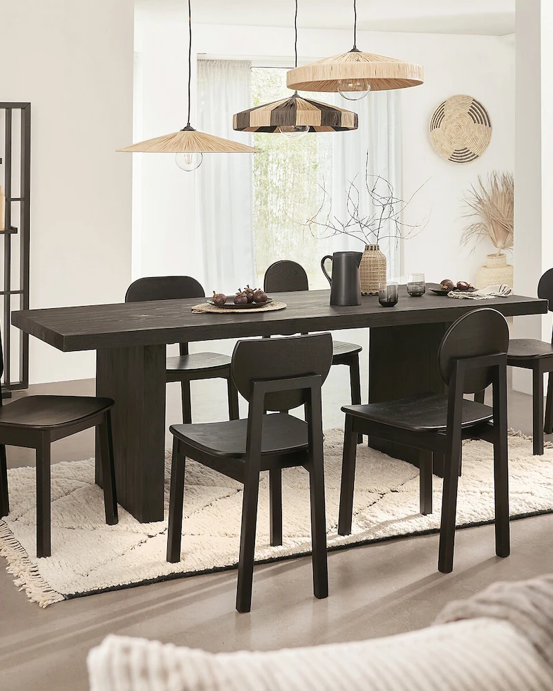 salle à manger ethnique noire avec table et chaises noires, tapis berbère et suspensions en fibres
