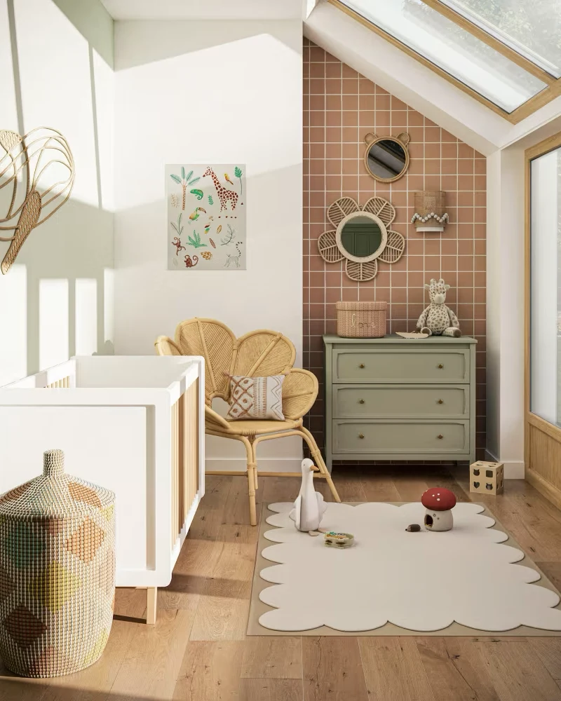 Commode bébé vert sauge à trois tiroirs dans une chambre mansardée avec mur de carreaux