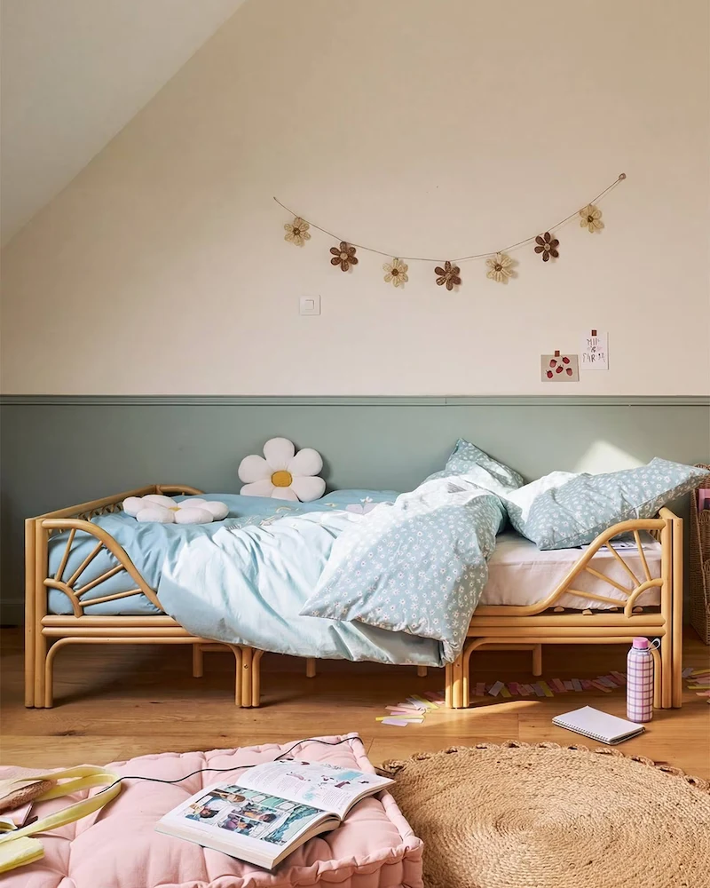 Lit enfant bas à l'aspect rotin avec tête de lit en forme de soleil dans une chambre mansardée