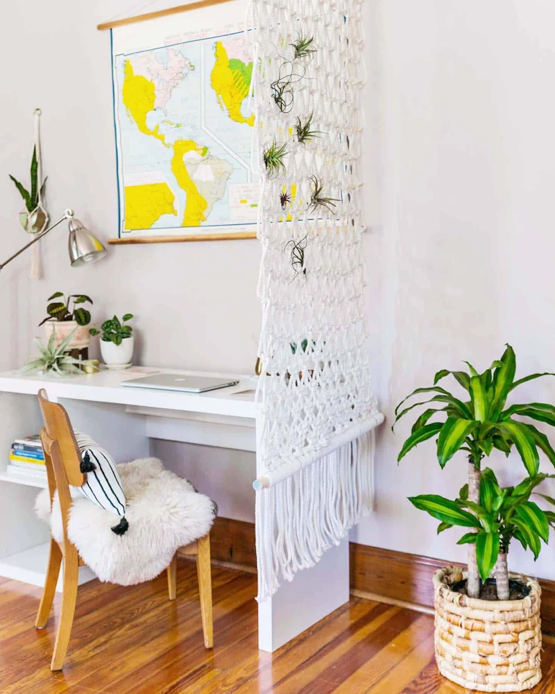 Grande cloison en macramé blanc suspendue séparant un coin bureau
