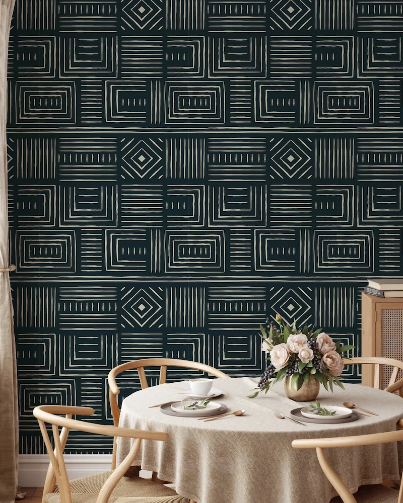 salle à manger avec papier peint ethnique vert foncé à motifs géométriques et table ronde nappée