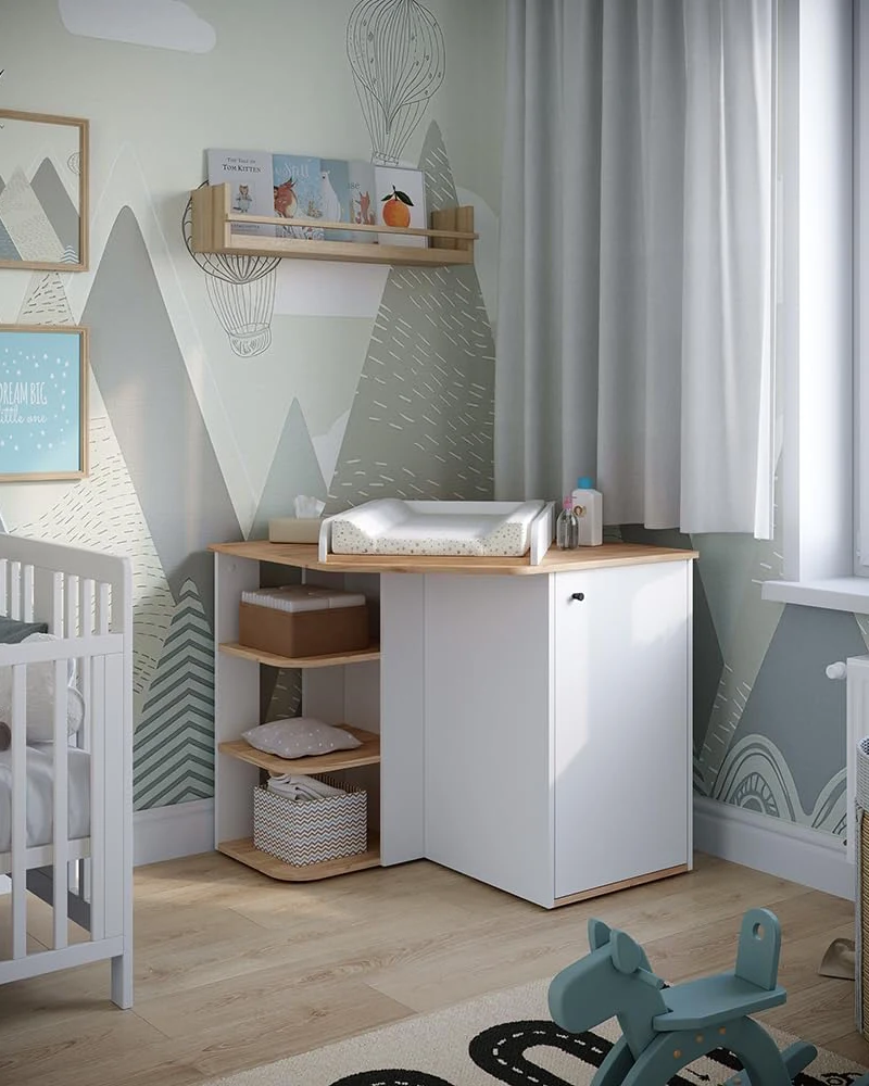 Meuble à langer blanc et bois avec étagères ouvertes et porte dans une chambre bébé à mur montagne