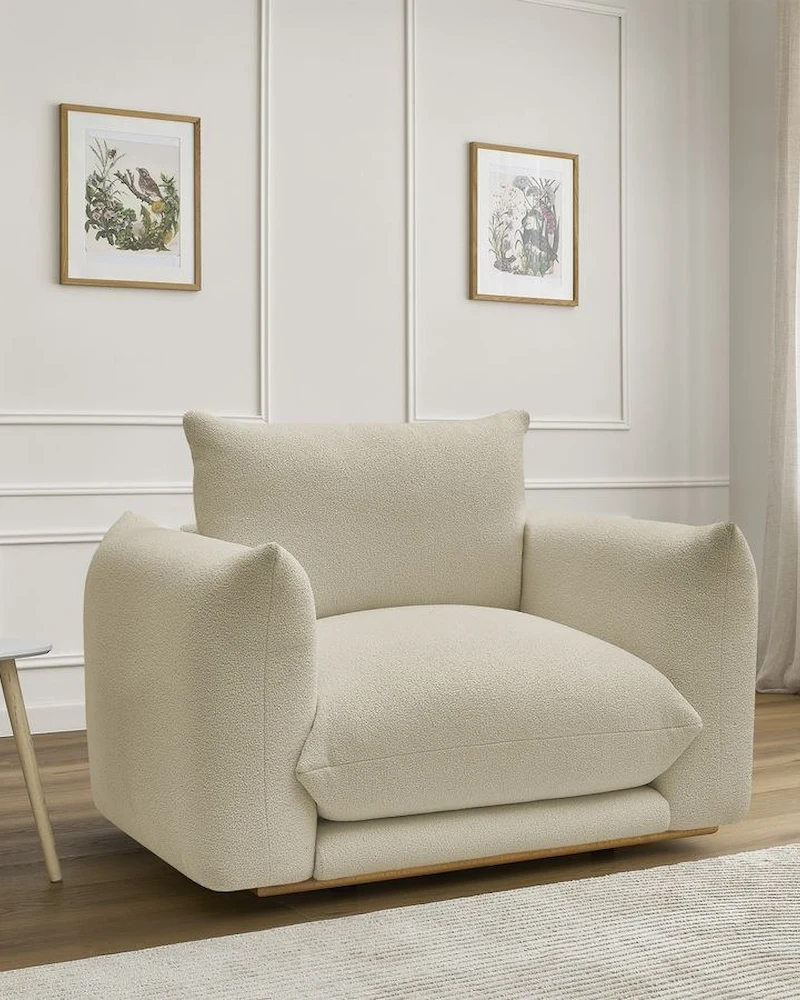 Grand fauteuil Ernest en bouclette beige aux lignes arrondies et coussins généreux dans un salon blanc