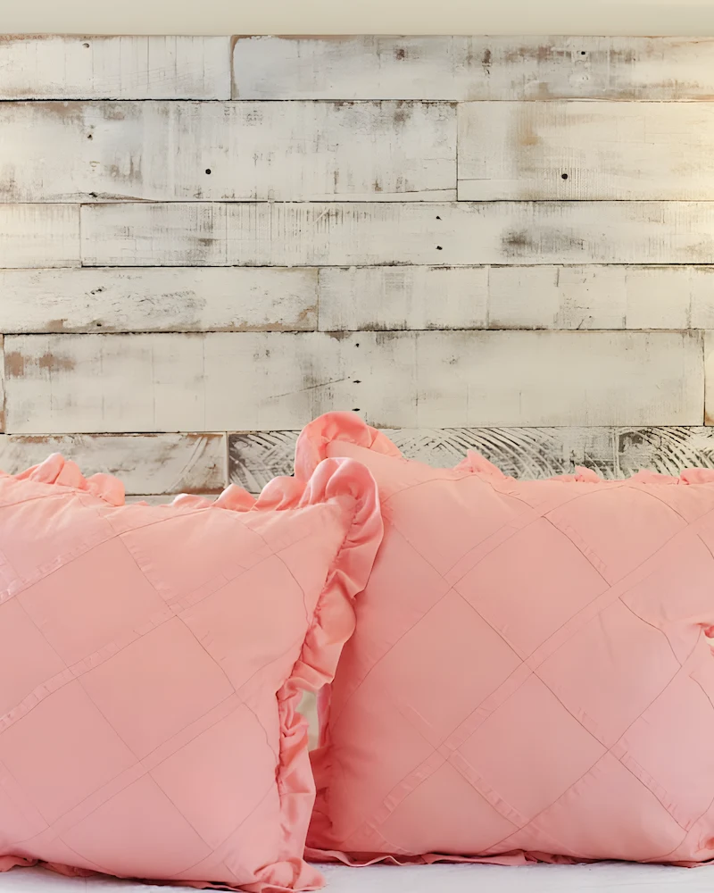 Tête de lit en planches de palette blanchies et vieillies avec deux appliques et coussins roses