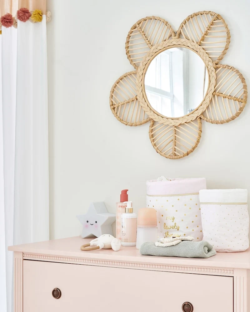 Miroir fleur Flora en rotin de Maisons du Monde au-dessus d'une commode