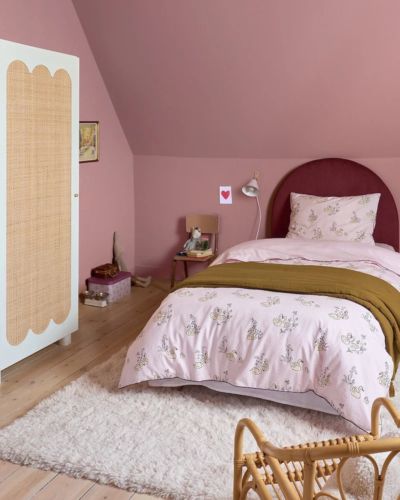 Tête de lit Bowy en velours côtelé bordeaux arrondie au-dessus d'un lit d'enfant