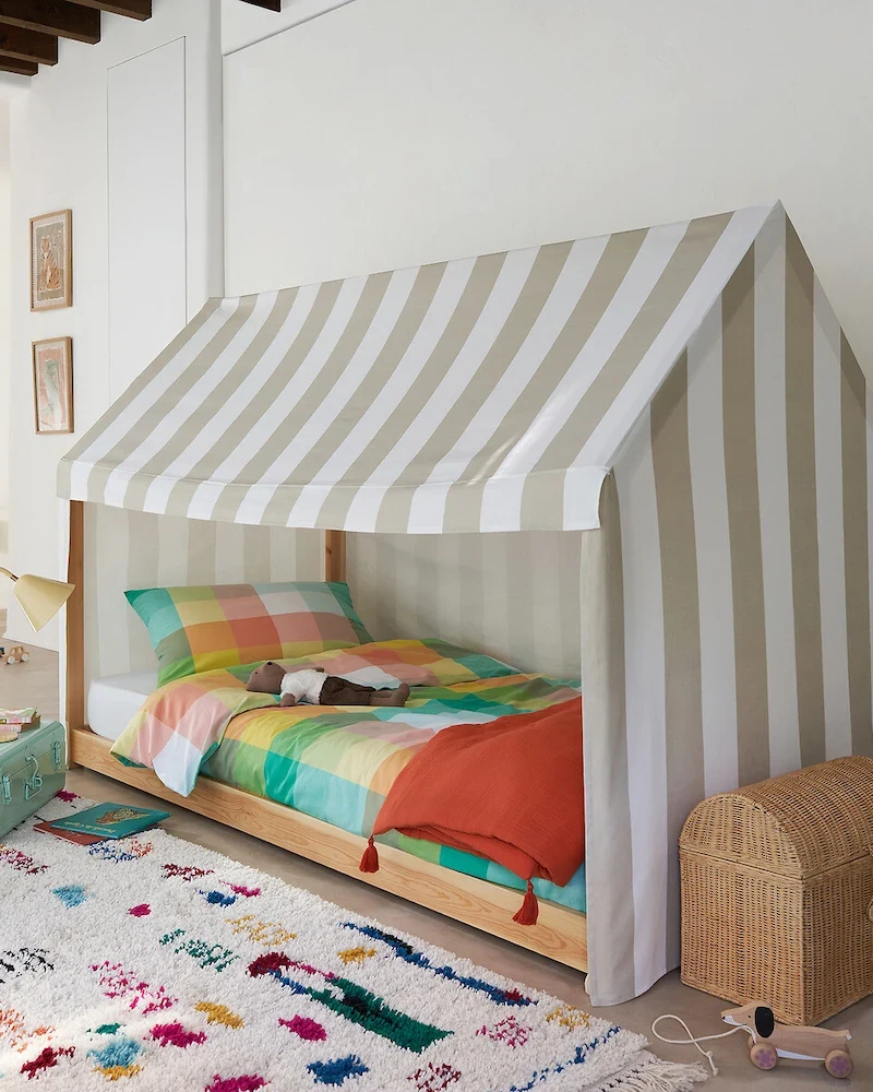 Lit cabane Archi en pin massif avec toit en tissu rayé dans une chambre colorée