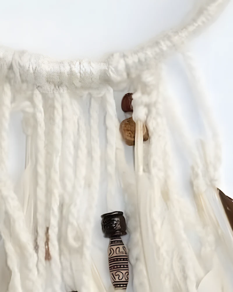 Attrape-rêves en laine blanche avec perles en bois et plumes
