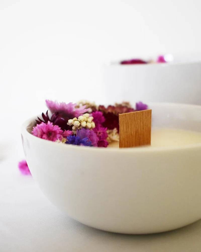 Bougie dans un bol blanc décorée de fleurs séchées