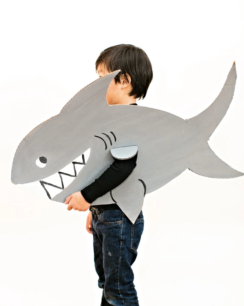 Enfant portant un costume de requin en carton peint