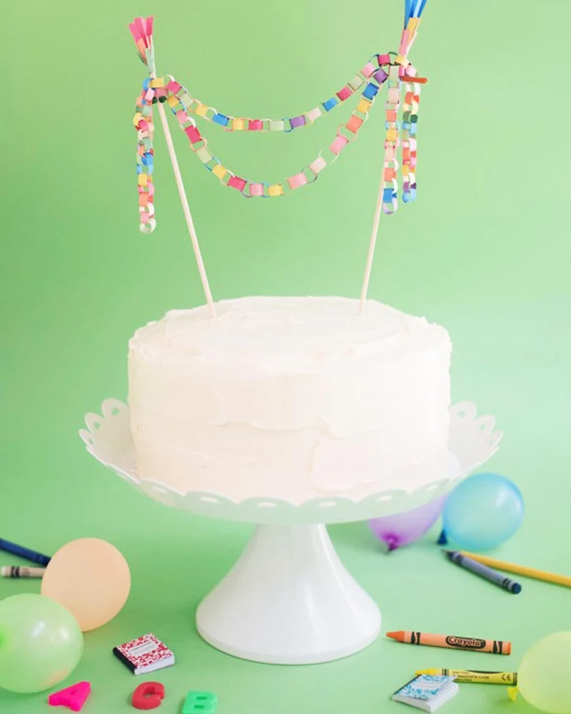 Gâteau blanc surmonté d'une mini guirlande en chaîne de papier coloré