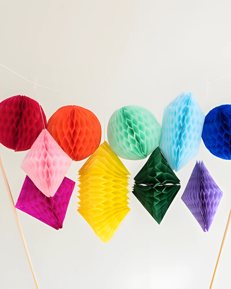 Gâteau surmonté de pompons alvéolés colorés sur des pics