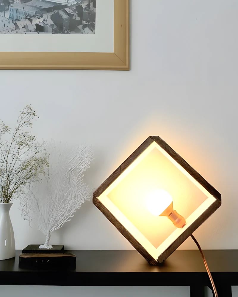 Lampe cube en bois clair posée sur une pointe