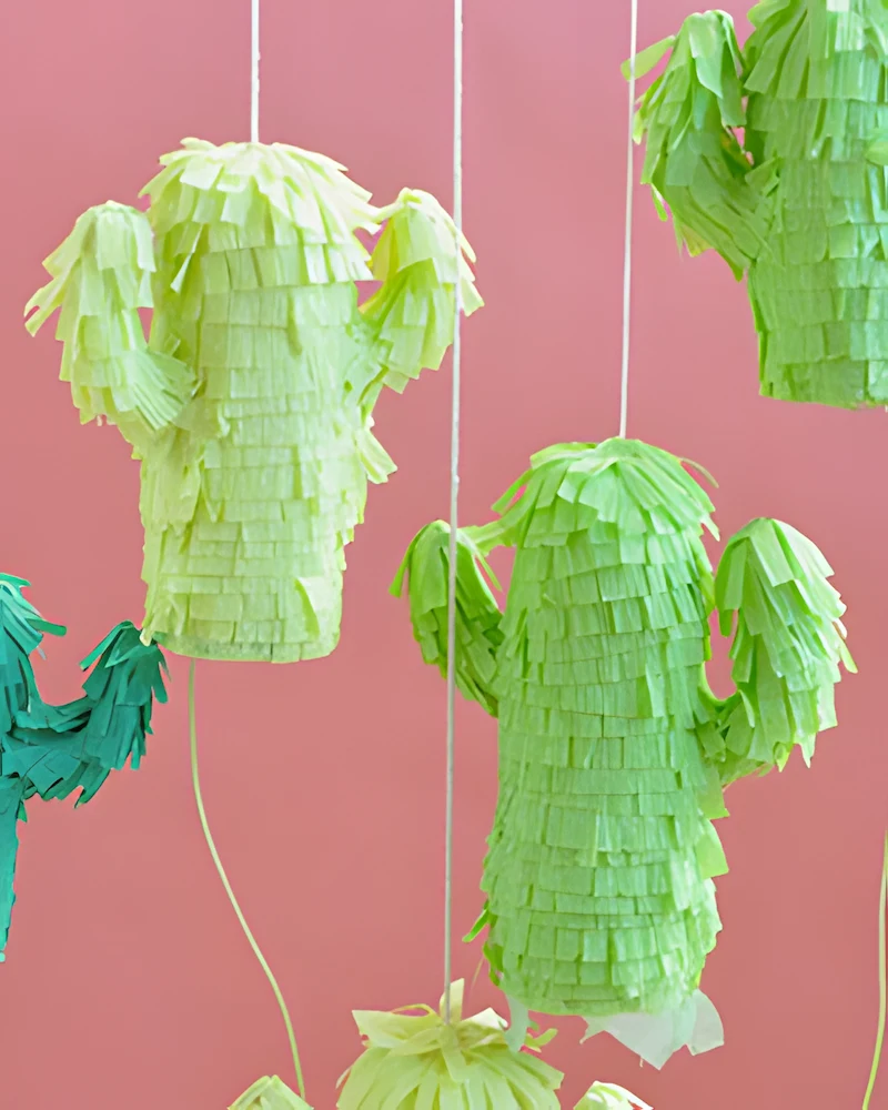 Petites piñatas vertes en forme de cactus suspendues