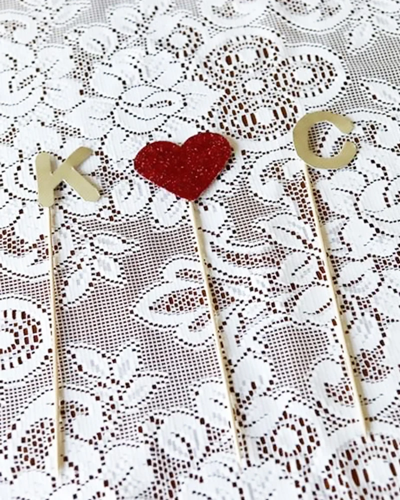 Pics décoratifs pailletés dorés et argentés sur un fond de dentelle