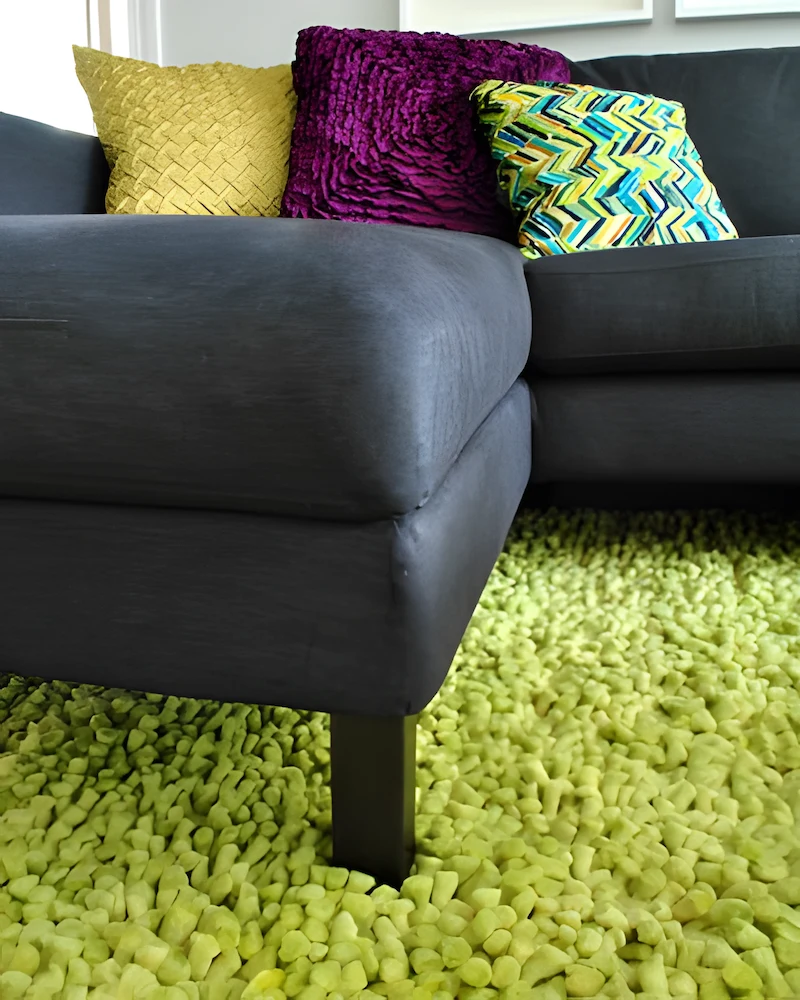 Pied de canapé repeint en bronze sur un tapis vert