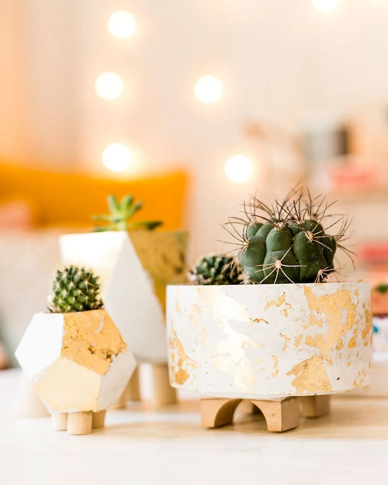 Pots en ciment facettés à pieds en bois décorés de feuille d'or