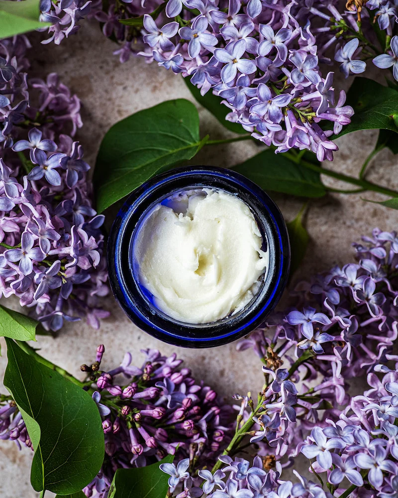 Pot de déodorant maison entouré de lilas