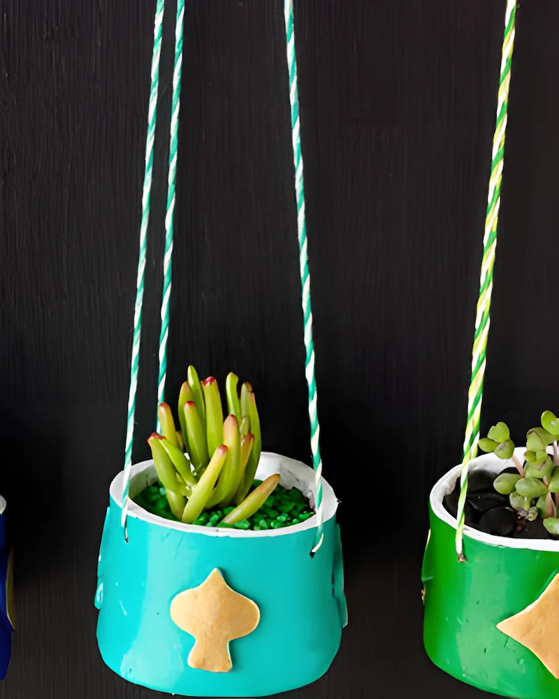 Pots suspendus en pâte autodurcissante peints avec des succulentes