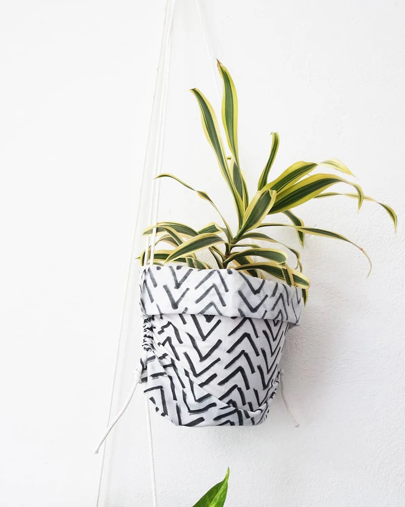 Sac en tissu graphique suspendu par une corde avec une plante