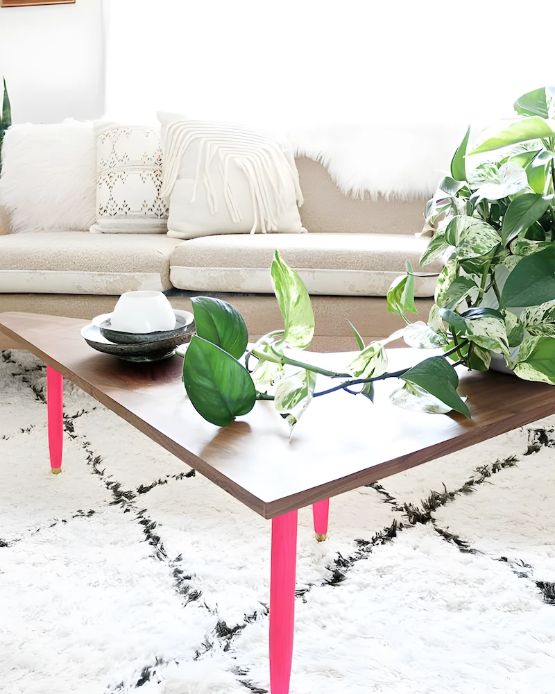 Table basse boomerang en noyer sur pieds fuselés roses