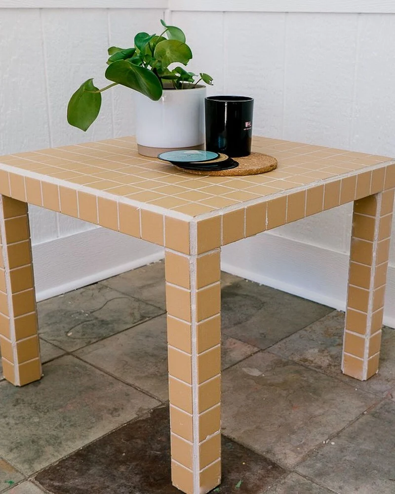 Table Lack entièrement recouverte de petits carreaux beiges et joints blancs