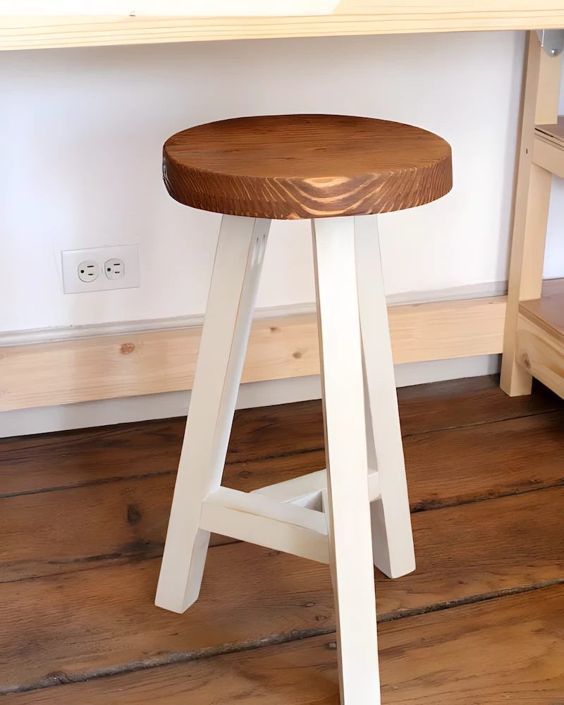 Tabouret à trois pieds blancs et assise ronde teintée