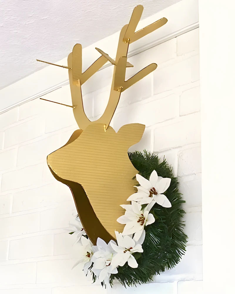 Tête de cerf en carton peinte en doré avec couronne de sapin