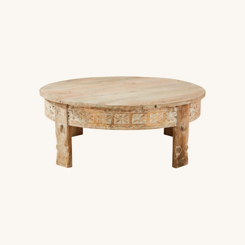 Table basse ronde en manguier massif sculpté chez Maisons du Monde